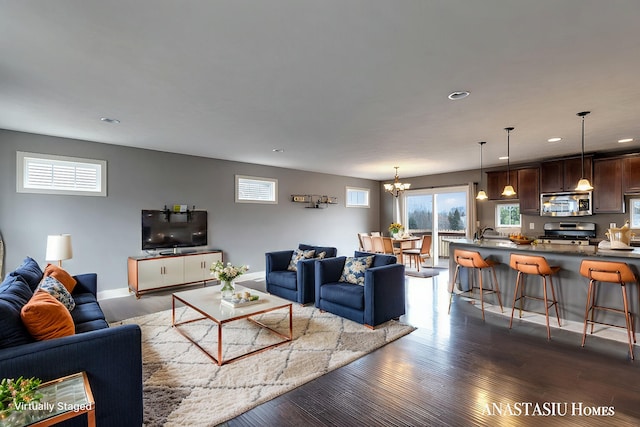 living room featuring a notable chandelier, baseboards, dark wood-style flooring, and recessed lighting