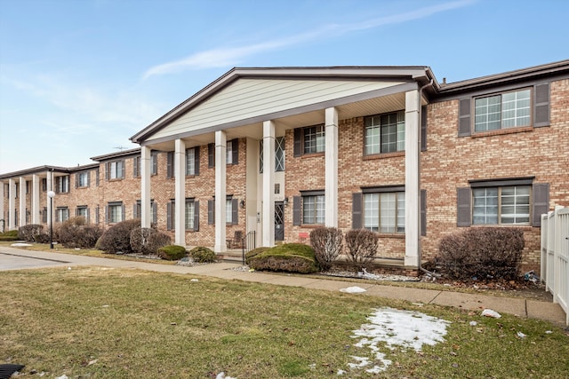 view of front facade featuring a front yard and brick siding