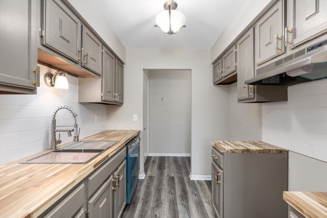 kitchen featuring a sink, wood counters, stainless steel dishwasher, and gray cabinetry