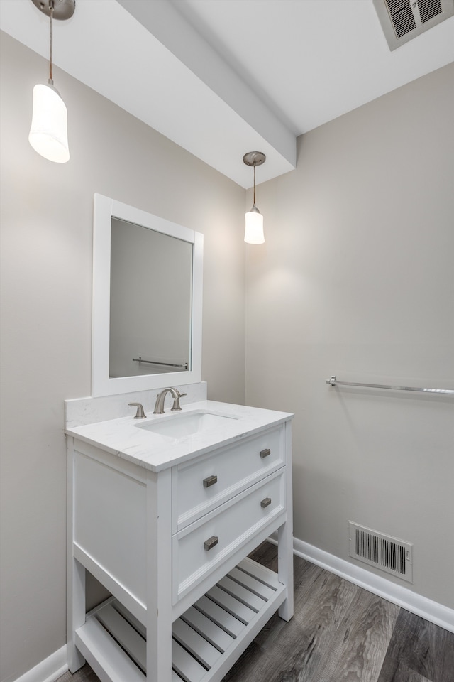 bathroom featuring wood finished floors, vanity, visible vents, and baseboards