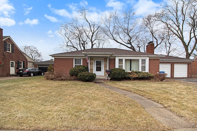 view of front of home featuring an attached garage, brick siding, a chimney, and a front yard