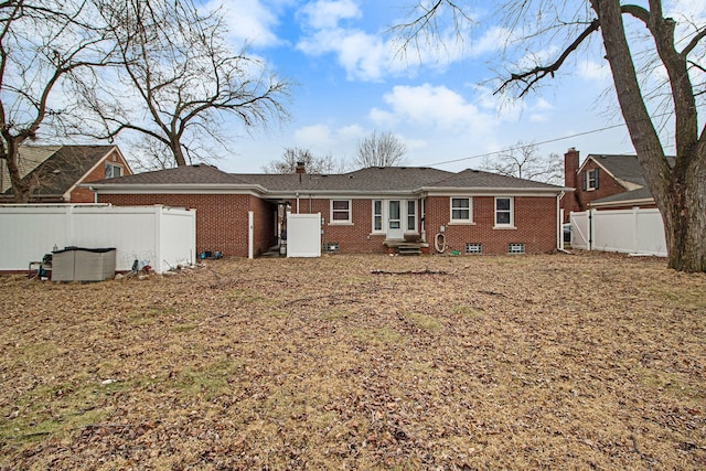 back of house featuring brick siding and a fenced backyard