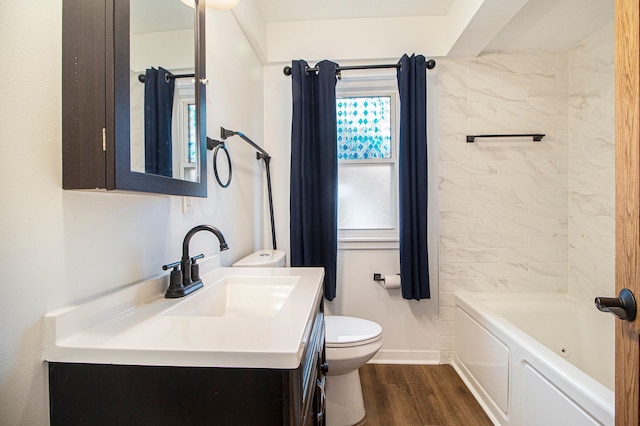 bathroom with toilet, wood finished floors, bathing tub / shower combination, vanity, and baseboards