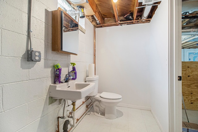 half bathroom featuring a sink, toilet, and baseboards