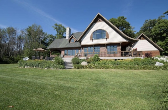 rear view of property featuring a yard and a chimney