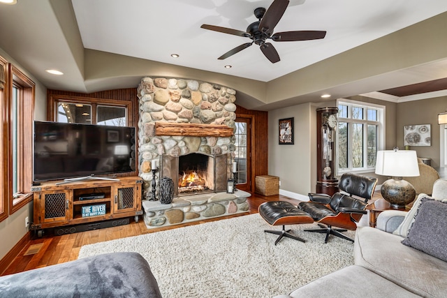 living area featuring a stone fireplace, recessed lighting, wood finished floors, visible vents, and baseboards