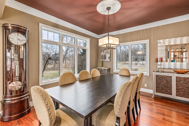 dining space with hardwood / wood-style flooring, baseboards, and crown molding