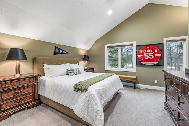 bedroom with baseboards, vaulted ceiling, and light colored carpet