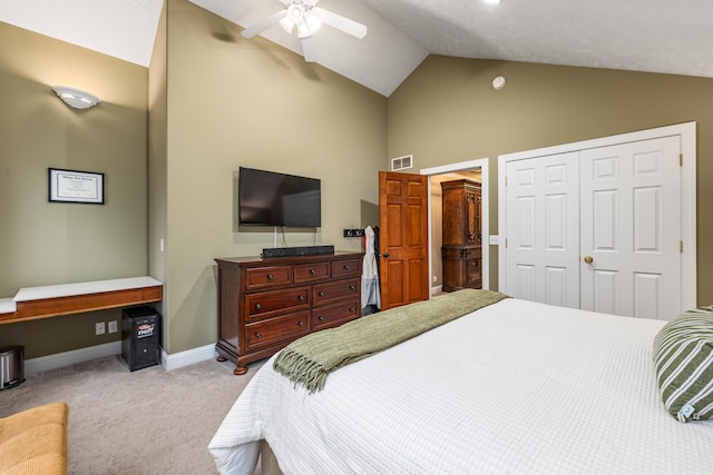 carpeted bedroom featuring lofted ceiling, a closet, visible vents, ceiling fan, and baseboards