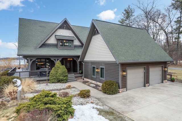 view of front of home with driveway, a shingled roof, a porch, and an attached garage