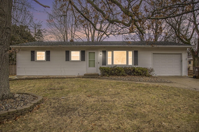 single story home with entry steps, a yard, an attached garage, and driveway