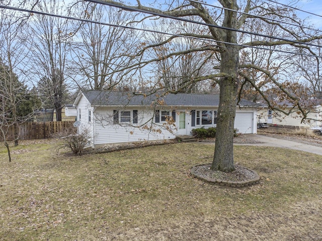 ranch-style house featuring driveway, an attached garage, fence, and a front yard