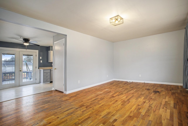 interior space featuring french doors, a ceiling fan, hardwood / wood-style floors, and baseboards