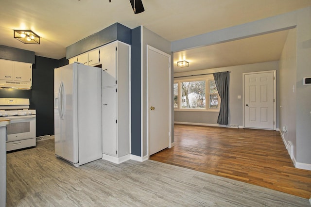 kitchen with white appliances, baseboards, under cabinet range hood, and light wood finished floors