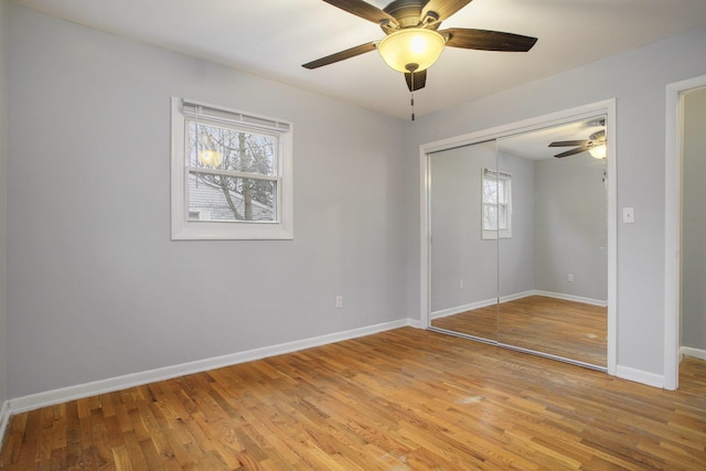 unfurnished bedroom featuring a ceiling fan, a closet, baseboards, and light wood finished floors