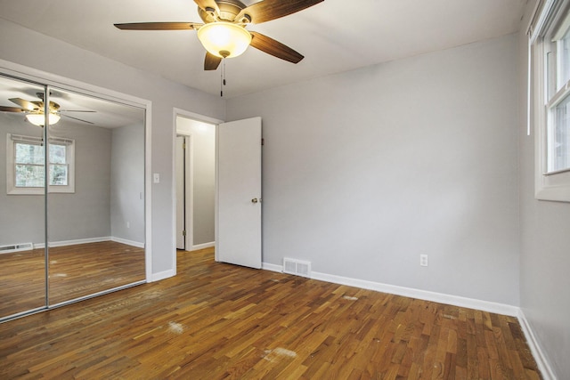 unfurnished bedroom with baseboards, visible vents, and wood finished floors