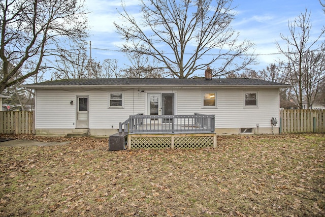 back of house featuring a yard, a chimney, a wooden deck, and fence