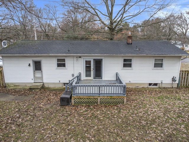 back of property featuring a deck, roof with shingles, a chimney, and entry steps