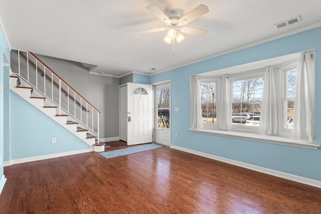 foyer with baseboards, crown molding, stairway, and wood finished floors