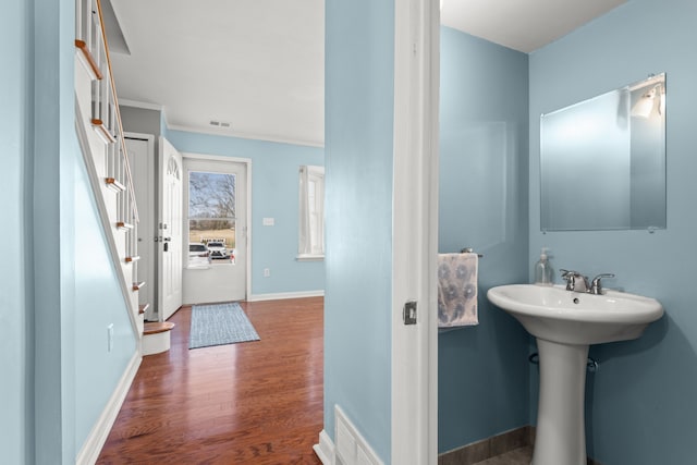 bathroom with a sink, visible vents, baseboards, and wood finished floors