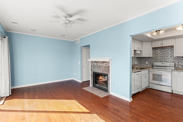 kitchen featuring white appliances, baseboards, dark wood-style floors, tasteful backsplash, and crown molding