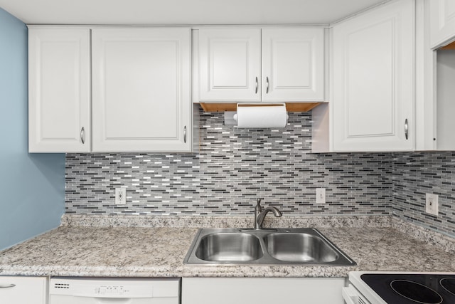 kitchen with decorative backsplash, white cabinets, white dishwasher, light countertops, and a sink