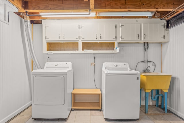 laundry room featuring cabinet space, light tile patterned floors, and independent washer and dryer