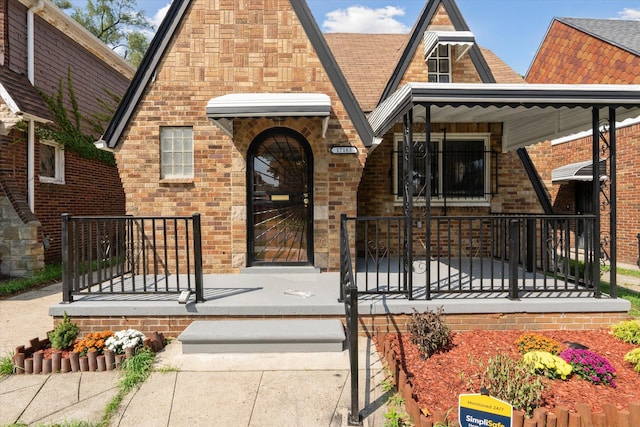 view of front of home with brick siding and a porch