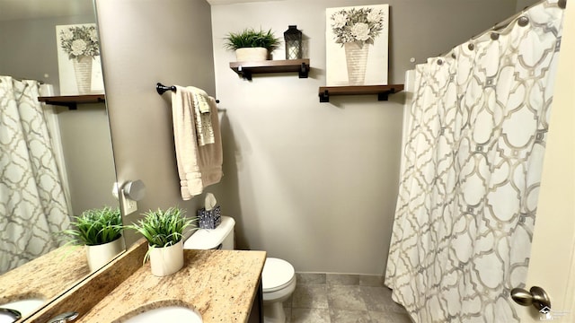 bathroom featuring toilet, curtained shower, baseboards, and vanity