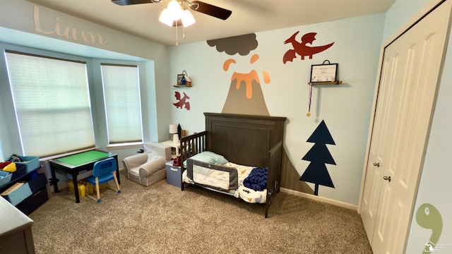 carpeted bedroom with a closet, ceiling fan, and baseboards