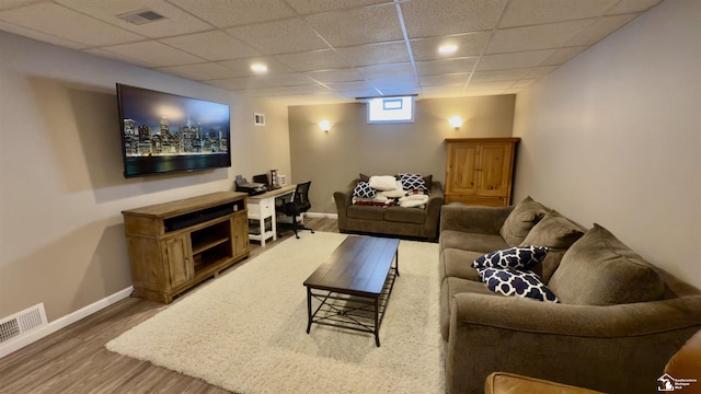 living room featuring a paneled ceiling, visible vents, and wood finished floors