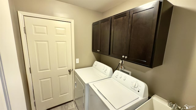 laundry area featuring washer and clothes dryer, a sink, and cabinet space