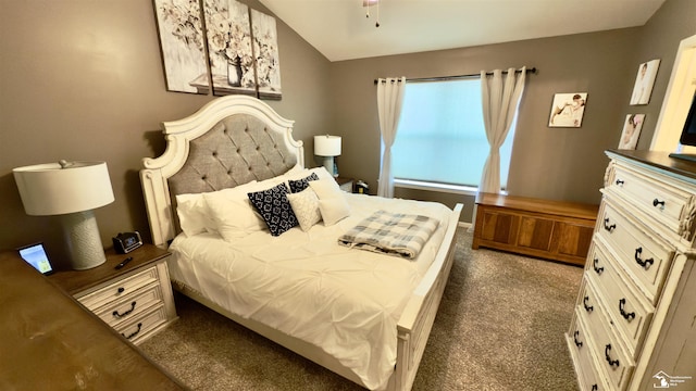 bedroom with dark colored carpet and vaulted ceiling