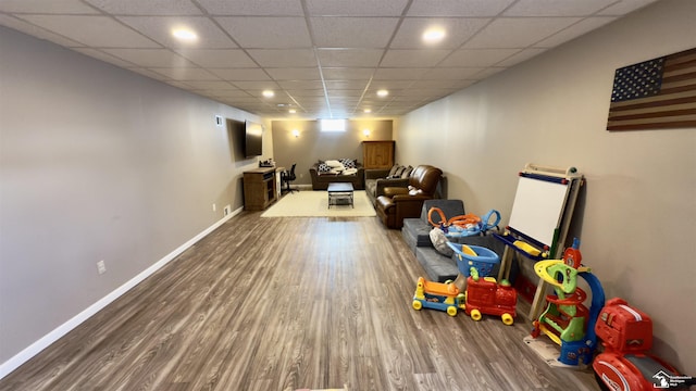 rec room featuring a paneled ceiling, recessed lighting, baseboards, and wood finished floors