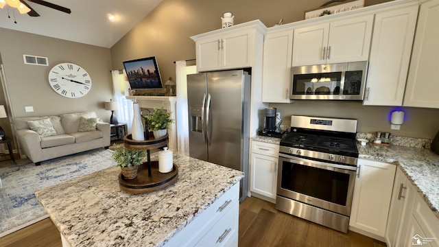 kitchen with dark wood-type flooring, visible vents, open floor plan, vaulted ceiling, and appliances with stainless steel finishes