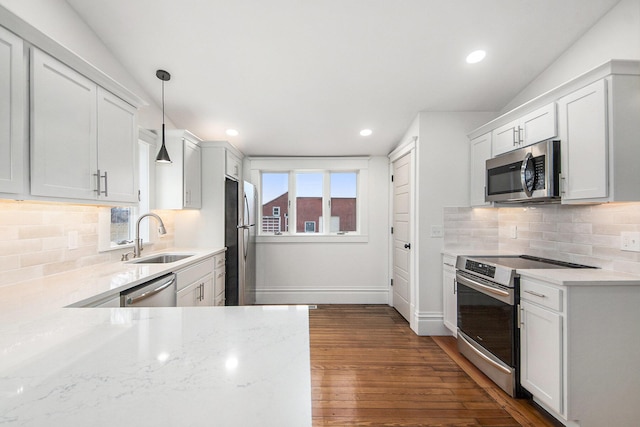 kitchen with appliances with stainless steel finishes, dark wood-style flooring, a sink, and a wealth of natural light