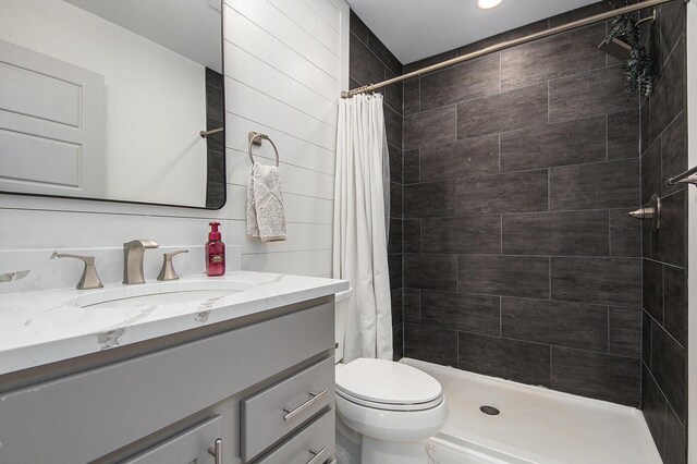 full bathroom featuring toilet, a stall shower, and vanity