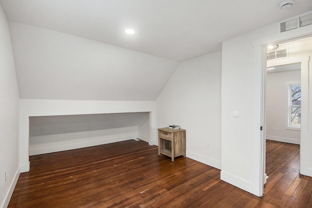 bonus room featuring lofted ceiling, wood-type flooring, visible vents, and baseboards