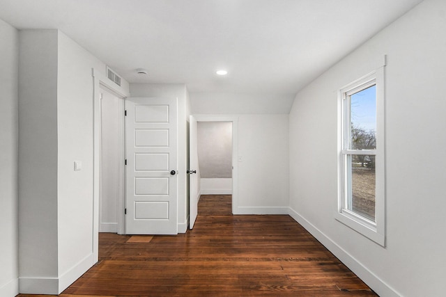 bonus room featuring dark wood-style flooring, visible vents, and baseboards