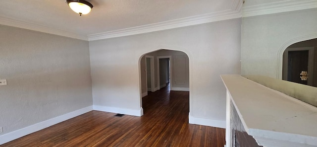 interior space with arched walkways, crown molding, baseboards, and wood finished floors