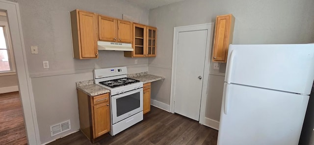 kitchen featuring under cabinet range hood, white appliances, visible vents, light countertops, and glass insert cabinets