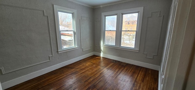 spare room with a wealth of natural light, dark wood-style flooring, and baseboards