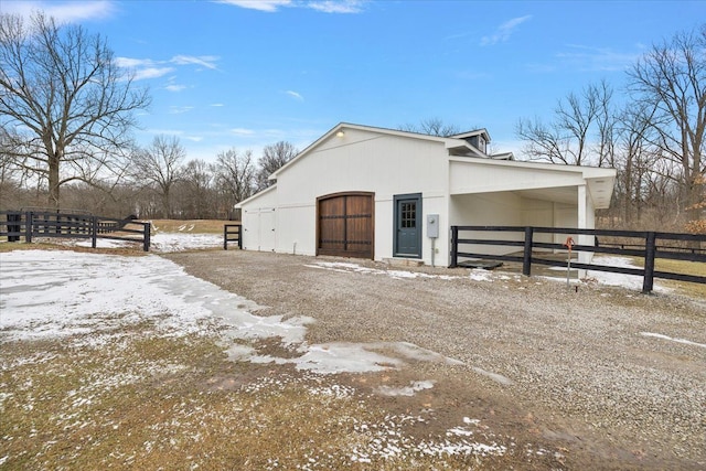 snow covered structure with an outbuilding and an exterior structure