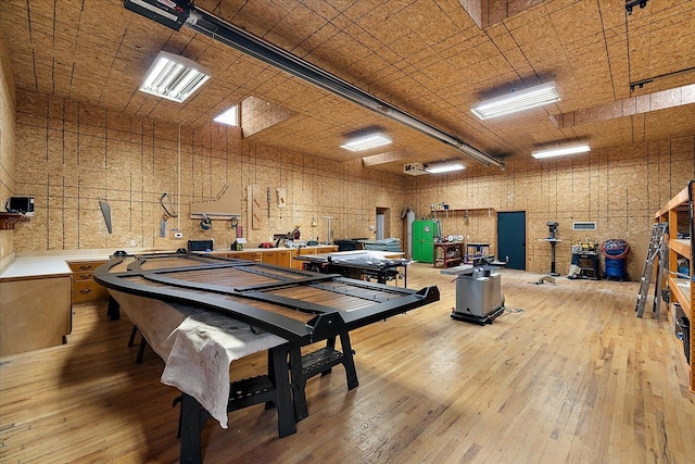 miscellaneous room with a garage, hardwood / wood-style floors, and a workshop area