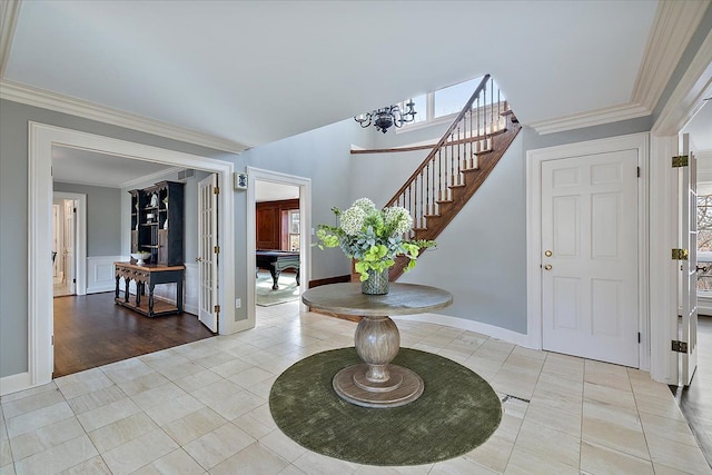 entrance foyer with crown molding, baseboards, stairs, and light tile patterned floors