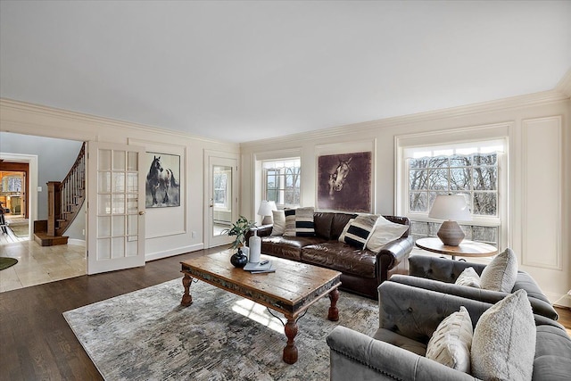 living area featuring ornamental molding, stairs, and wood finished floors