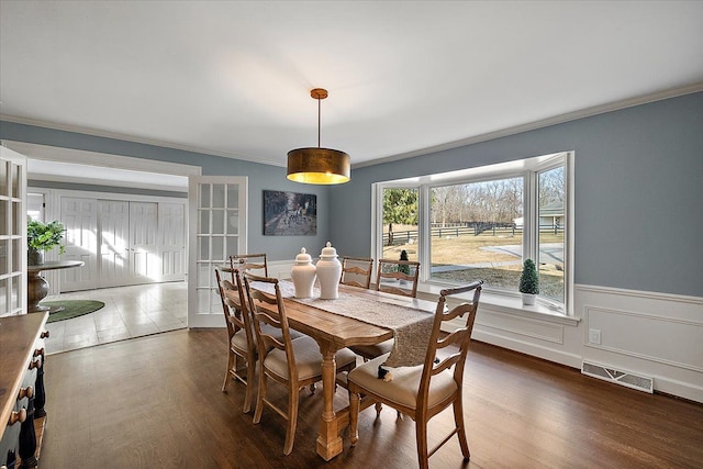 dining area with french doors, visible vents, wainscoting, ornamental molding, and dark wood-type flooring