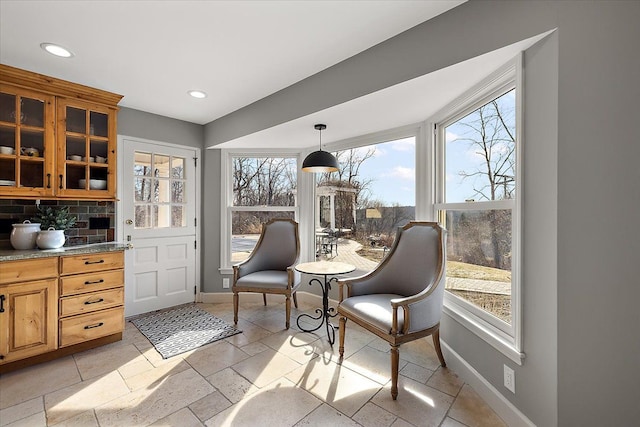 living area with baseboards, recessed lighting, and a wealth of natural light