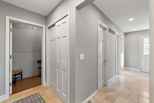 corridor featuring recessed lighting, baseboards, visible vents, and stone tile flooring