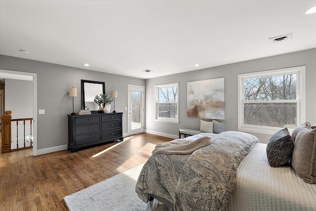 bedroom featuring baseboards, access to outside, wood finished floors, and visible vents